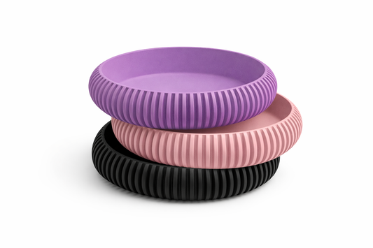 Three ribbed silicone bands in purple, pink, and black on a white background