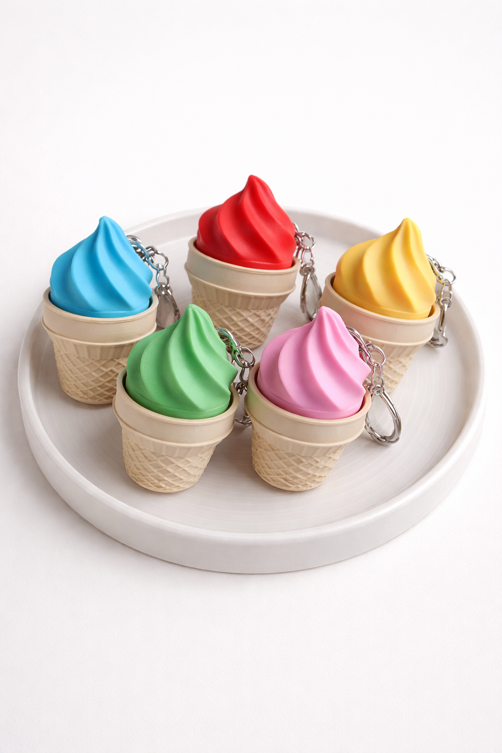 Colorful ice cream cone keychains on a white plate
