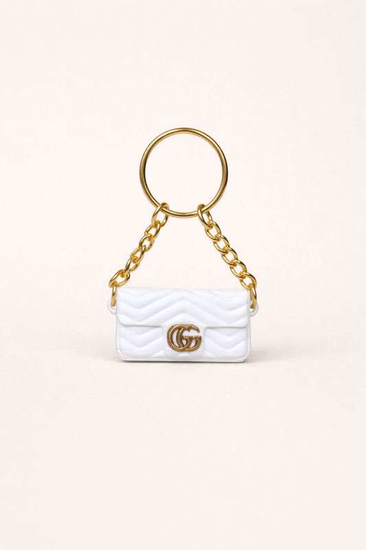 White handbag keychain with gold chain and logo on a white background