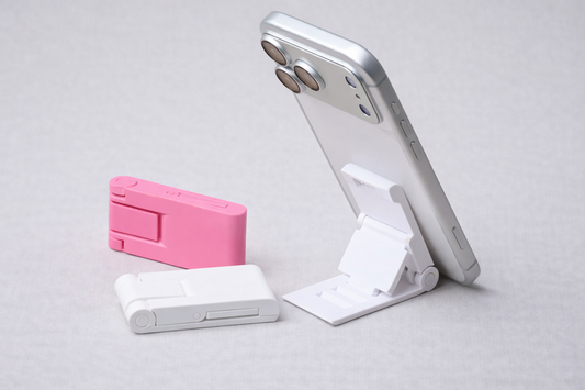 Phone stand with pink and white phone cases on a light gray background