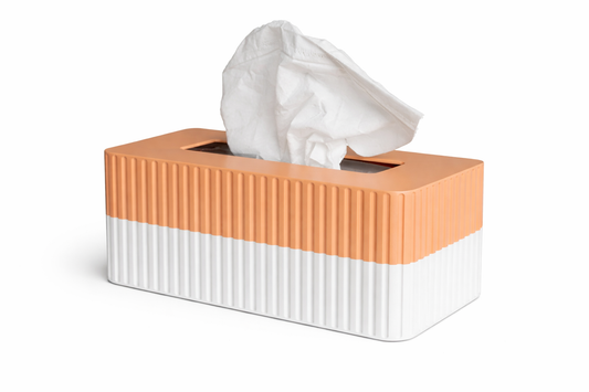 Tissue box with a ribbed texture in orange and white on a white background