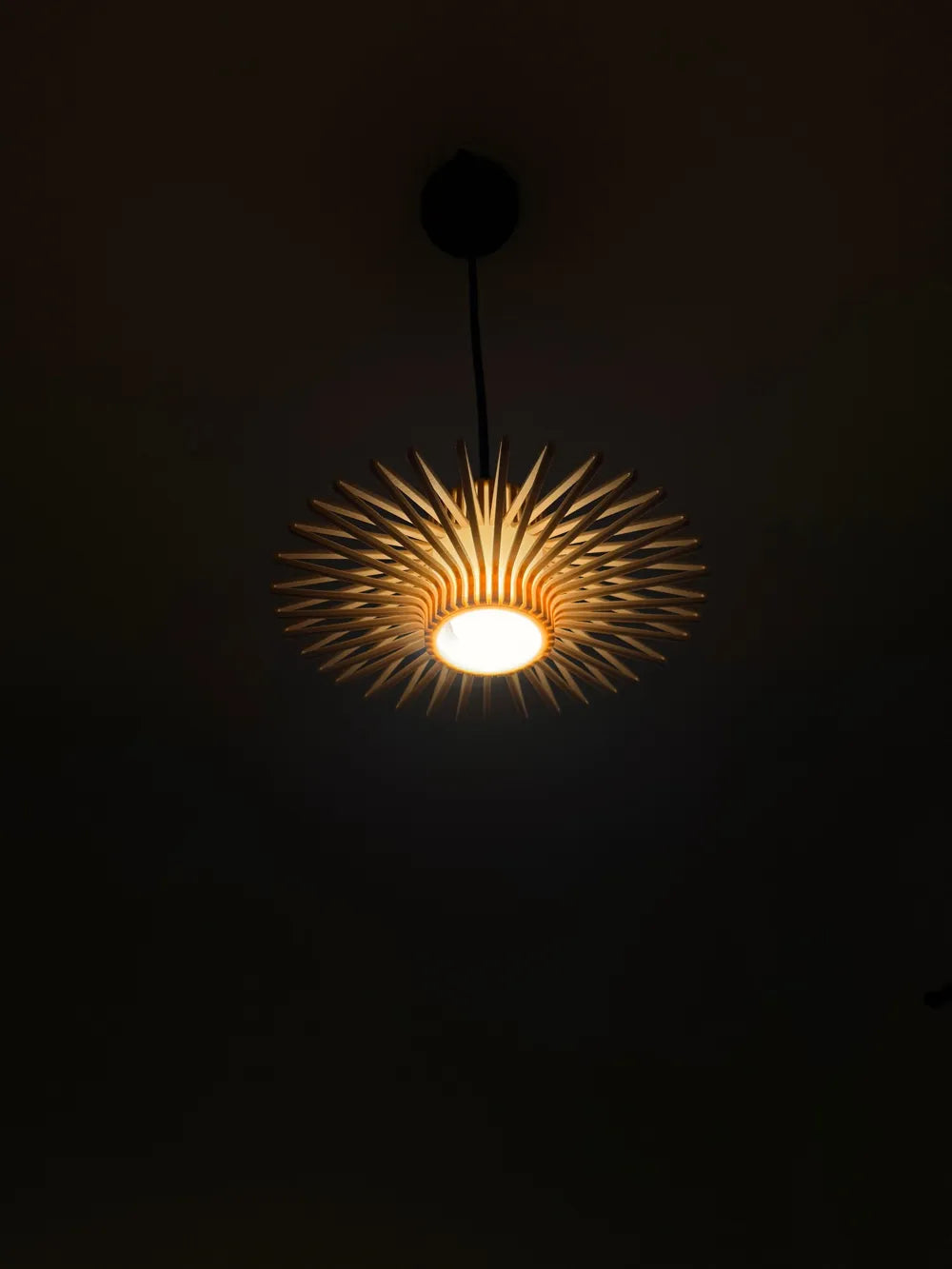 Modern pendant light with unique design against a dark background