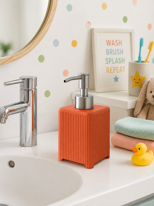 An orange ribbed soap dispenser with a silver pump sits on a white bathroom counter next to a chrome faucet, with a mirror, toothbrush holder, bunny toy, and rubber duck in the background.
