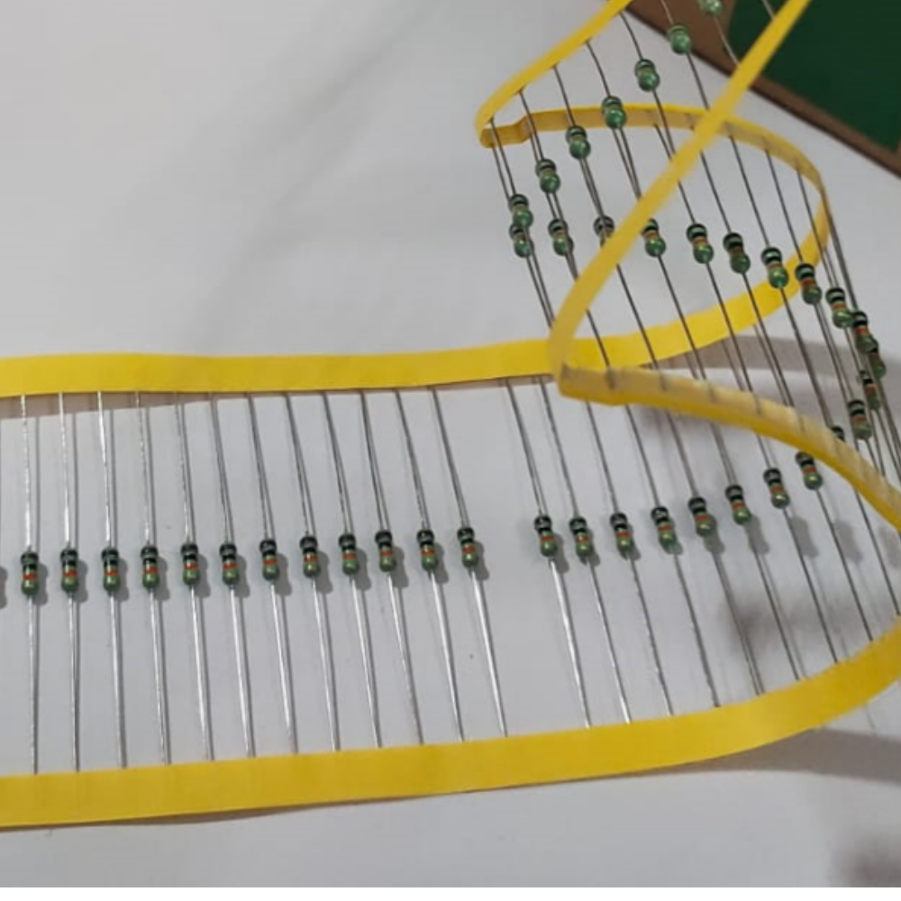 Row of resistors on a yellow holder against a white background