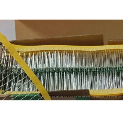Close-up of a box containing electronic resistors with a yellow tool in the foreground.