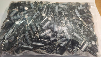 Bag of electronic components including capacitors and resistors on a white background
