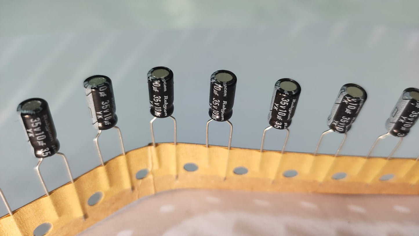 Row of black electrolytic capacitors on a white background