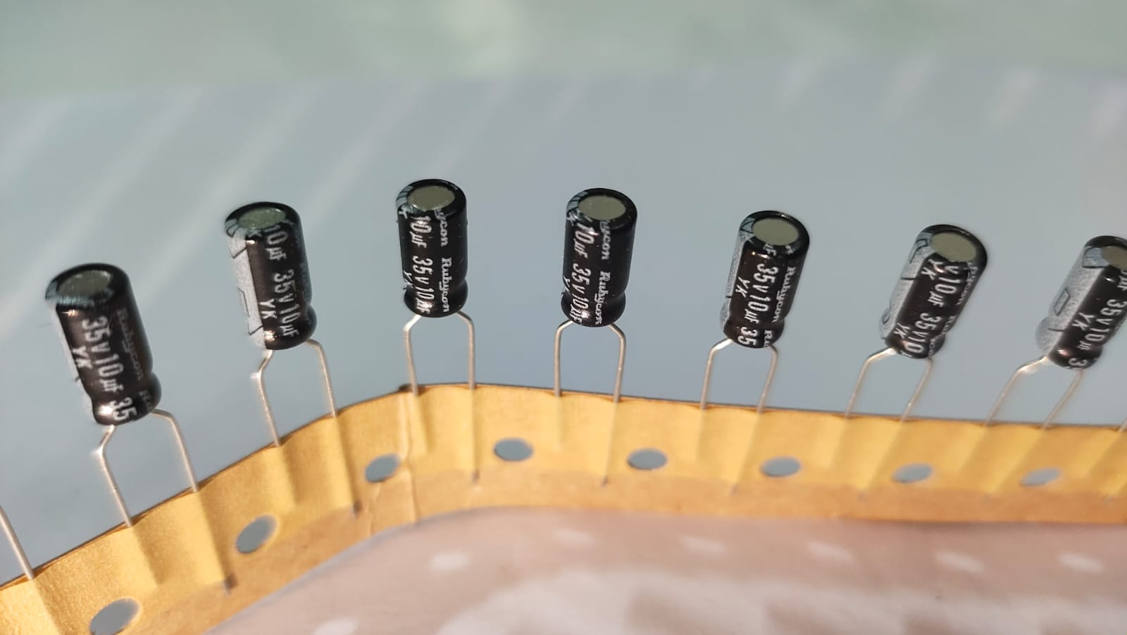 Row of black electrolytic capacitors on a white background