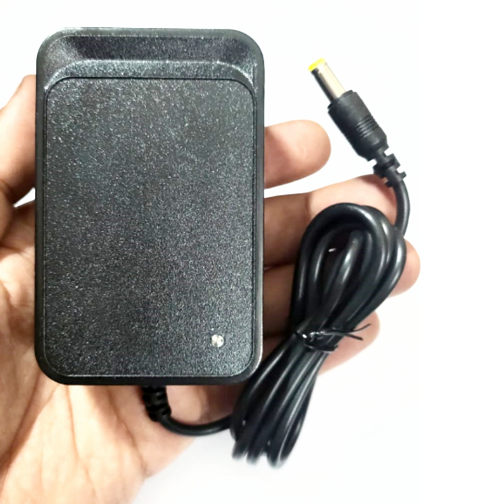 Black power adapter held in a hand with a white background