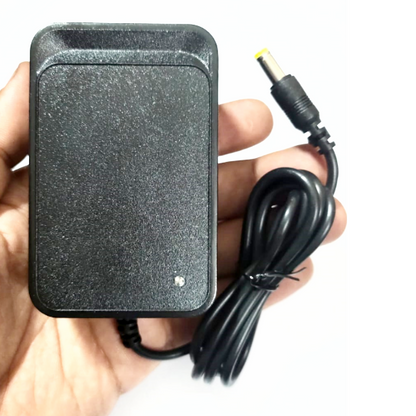Black power adapter held in a hand with a white background