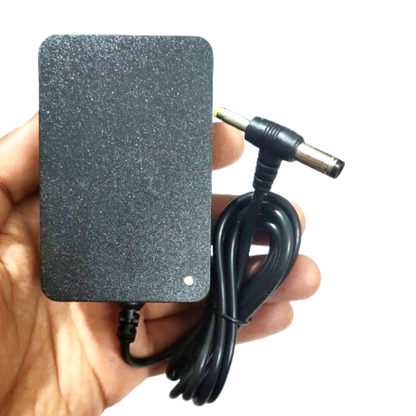 Black power adapter held in a hand with a white background