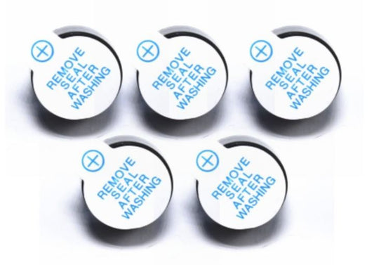 Five round white labels with text 'Remove Seal After Washing' on a light gray background