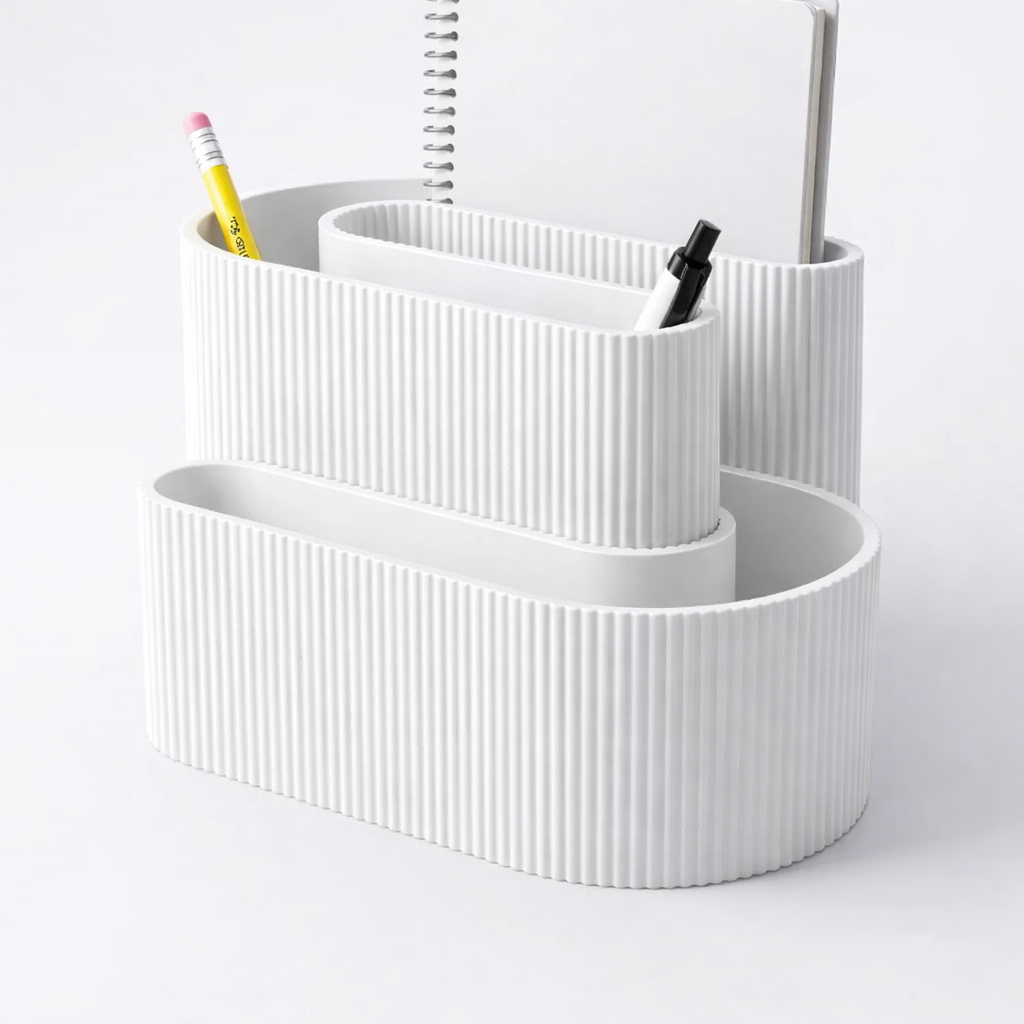 White ribbed desk organizer with stationery items on a light gray background