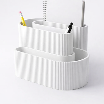 White ribbed desk organizer with stationery items on a light gray background