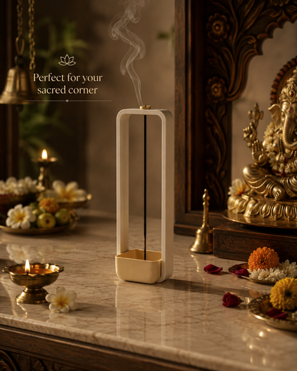 A tall rectangular incense burner with a white frame and gold base, shown on a marble altar with lit candles, flowers, and a decorative statue in a warm indoor setting. Text on the left reads 'Perfect for your sacred corner.