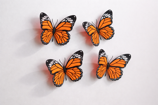 Four orange butterflies with black spots on a light gray background