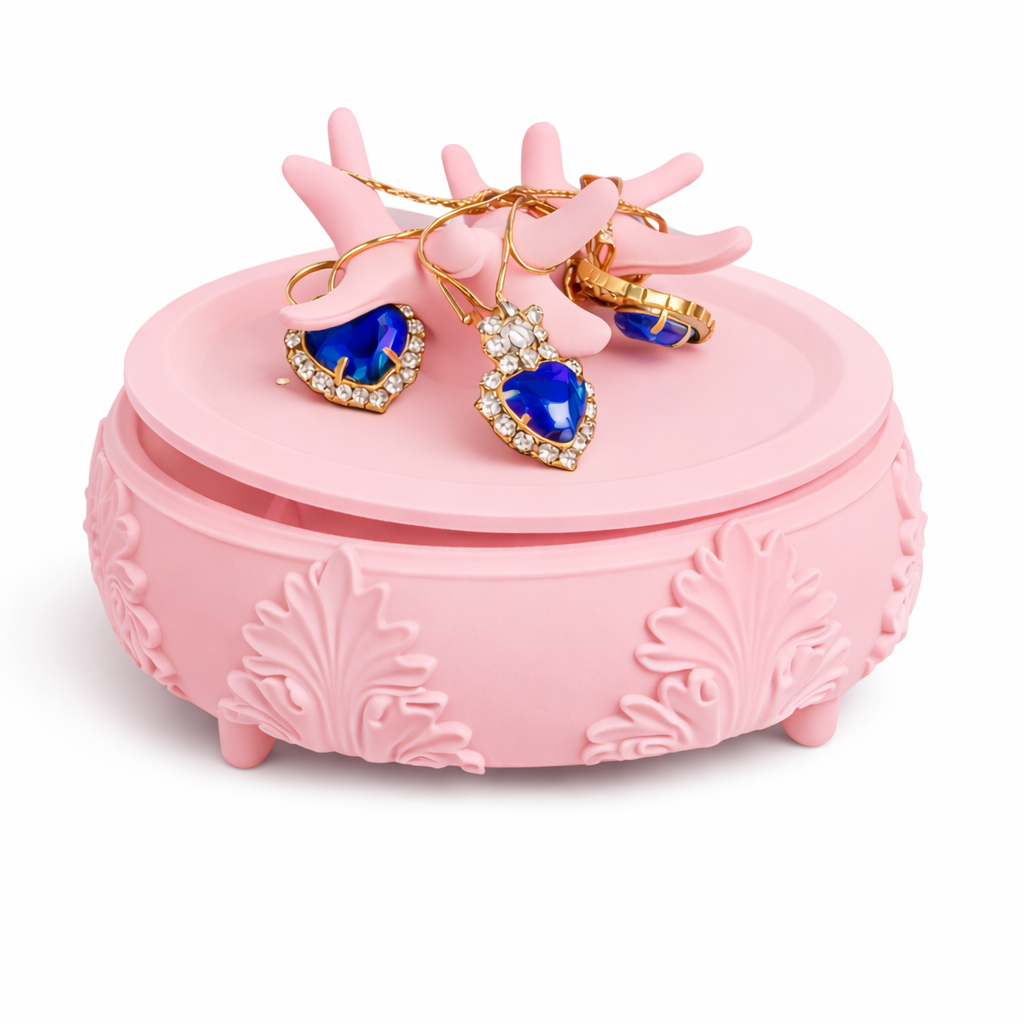 Pink jewelry box with heart-shaped blue gem earrings and gold necklaces on a white background