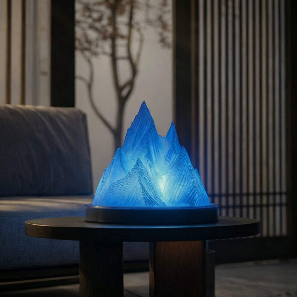 Blue mountain-shaped lamp on a table in a dimly lit room