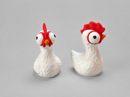 Two ceramic chicken figurines with red combs on a gray background