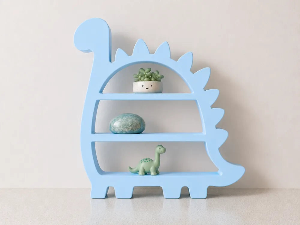 A light blue dinosaur-shaped wooden shelf with three tiers, styled with a small potted succulent, a blue-green stone, and a small green dinosaur figurine, set against a plain beige wall.