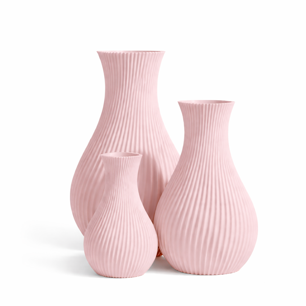 Set of three pink ribbed vases on a white background