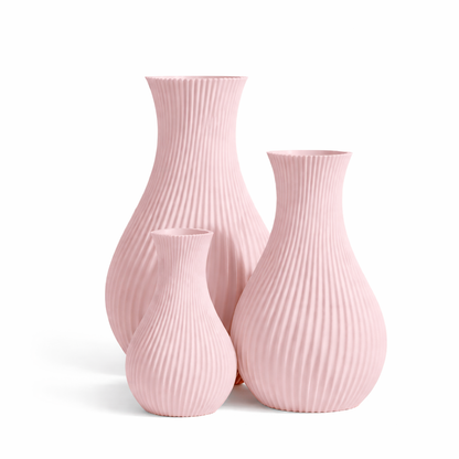 Set of three pink ribbed vases on a white background