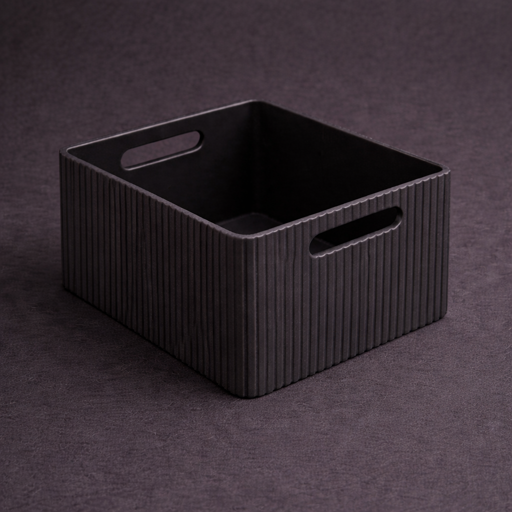 Black rectangular storage basket with handles on a dark background