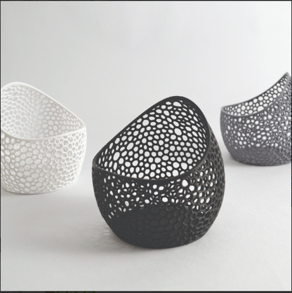 Three decorative bowls with unique perforated designs on a light gray background