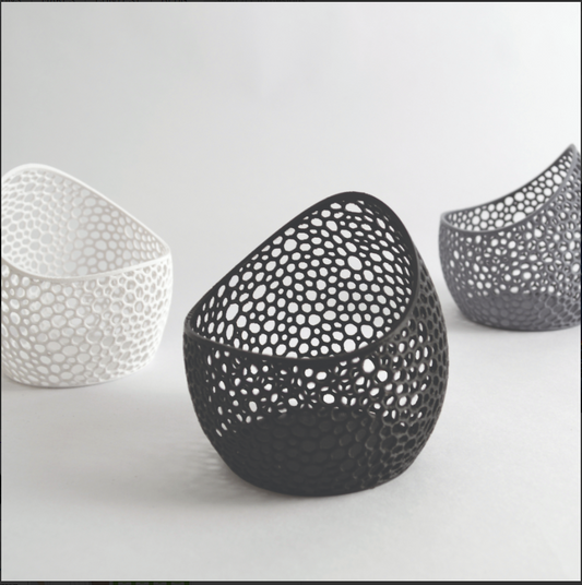 Three decorative bowls with unique perforated designs on a light gray background