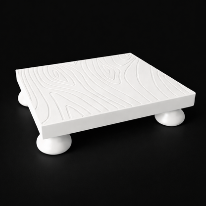 White decorative platform with rounded legs on a black background