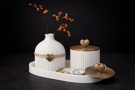 Decorative set with a white vase, candle holder, and heart-shaped objects on a dark background