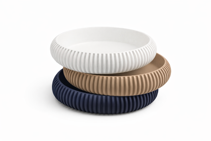 Three ribbed bowls in white, beige, and navy on a white background