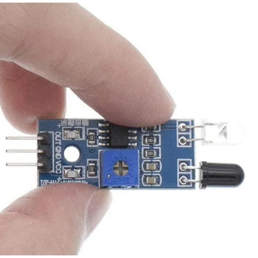 Electronic sensor module held between two fingers on a white background