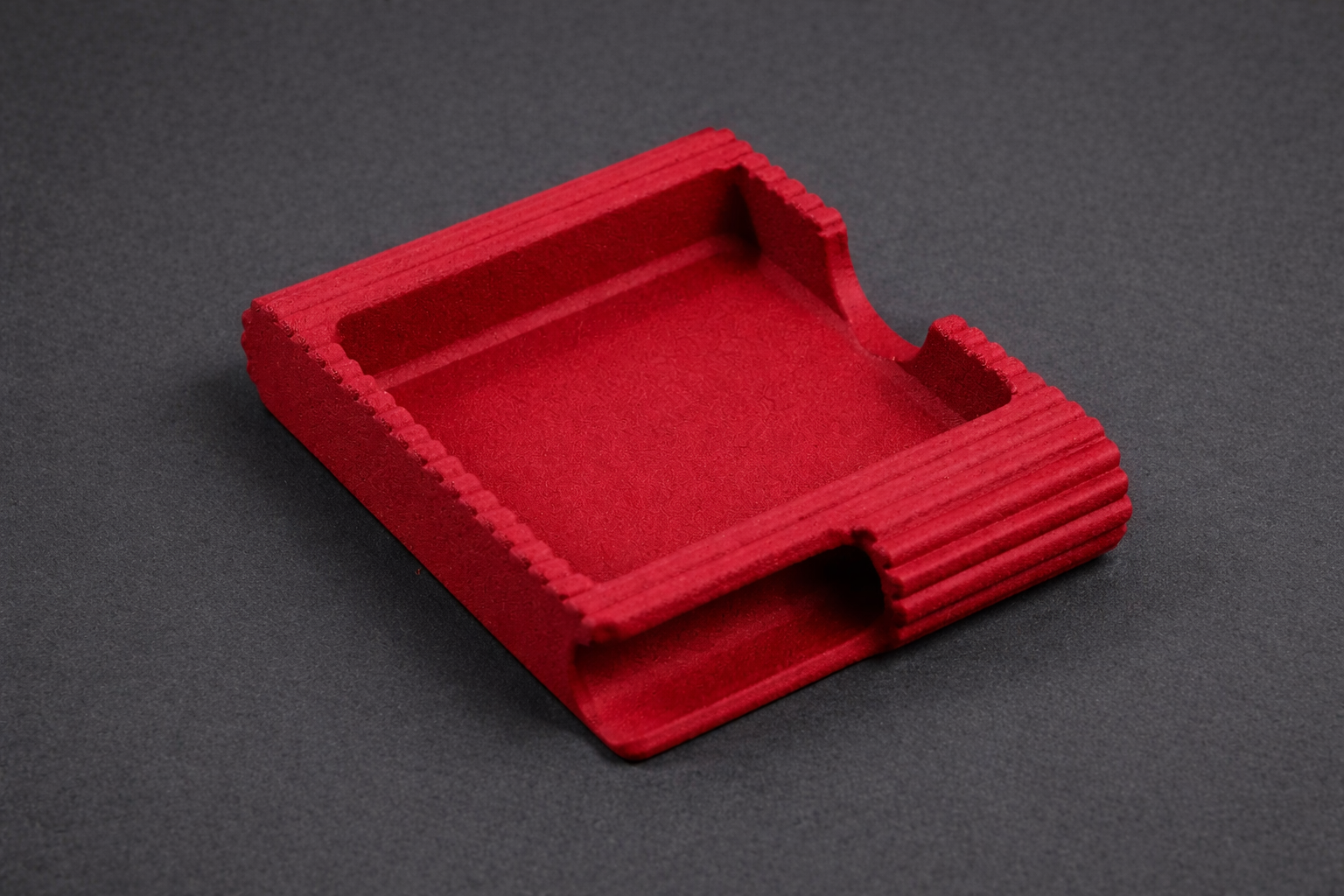 Red rectangular object with textured surface on a gray background