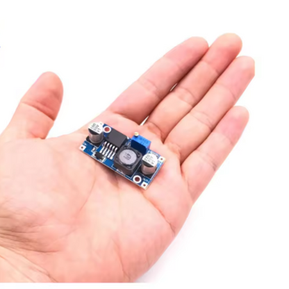 Small electronic module held in a hand against a white background