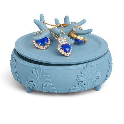Blue jewelry box with heart-shaped blue stones and gold accents on a white background