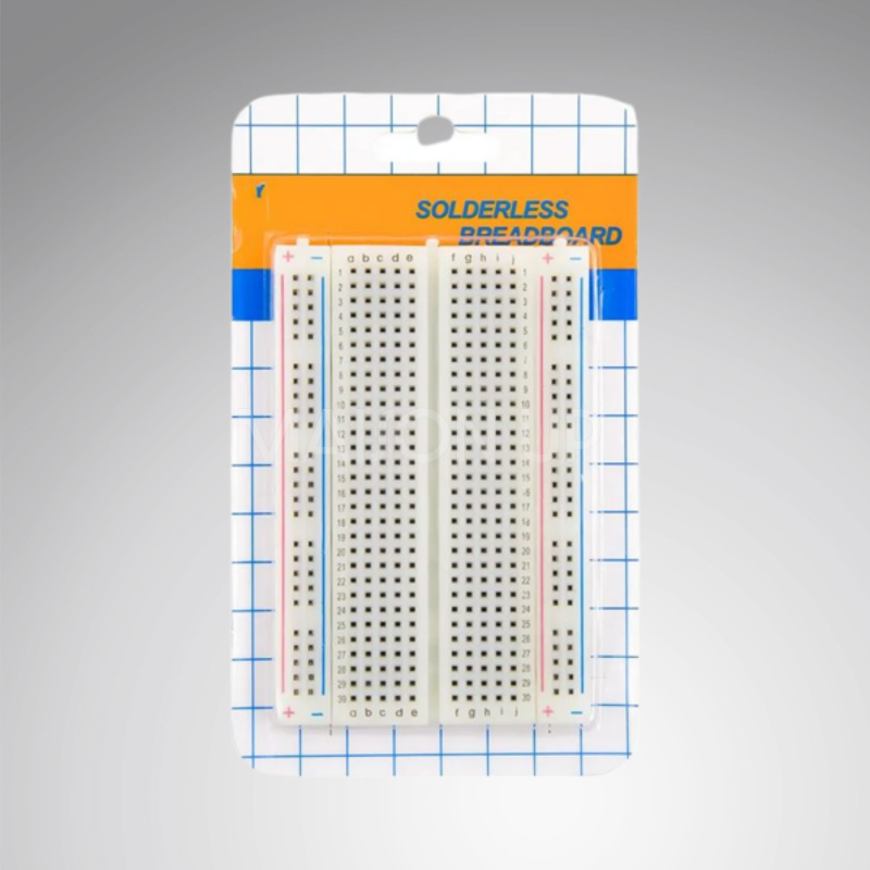 Solderless breadboard in packaging with a gray background