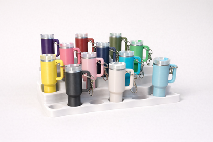 Collection of colorful insulated mugs with keychains on a white background