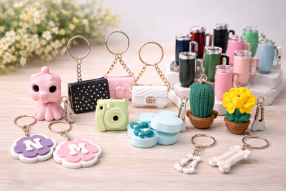 Collection of various keychains and small decorative items on a wooden surface with a blurred floral background.
