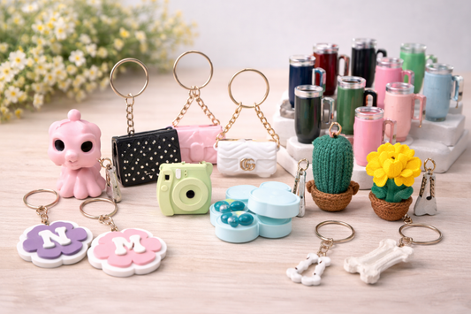 Collection of various keychains and small decorative items on a wooden surface with a blurred floral background.