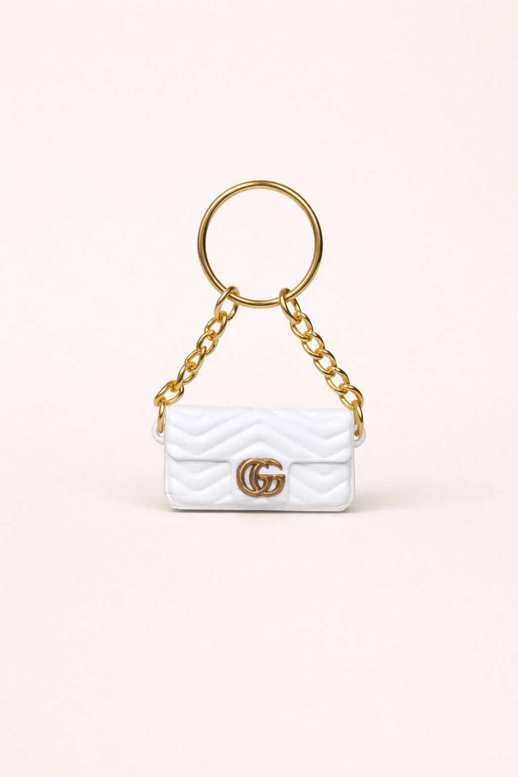 White handbag keychain with gold chain and logo on a white background