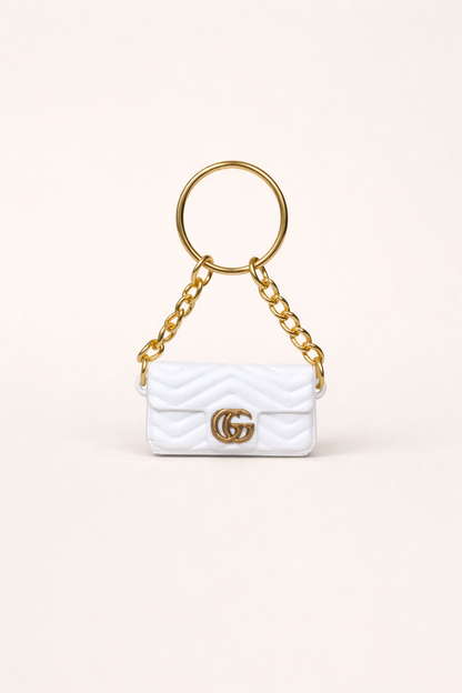 White handbag keychain with gold chain and logo on a white background