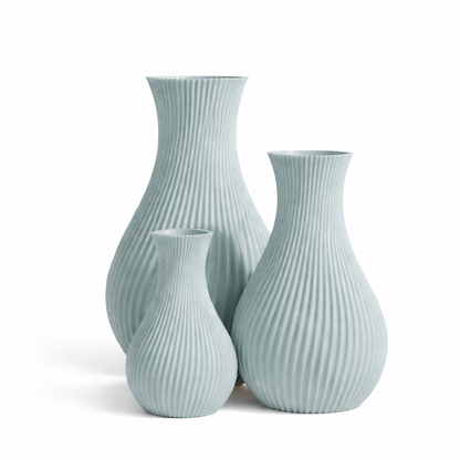 Set of three light blue ribbed vases on a white background