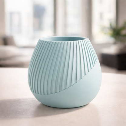 Light blue ceramic vase with ribbed texture on a light surface