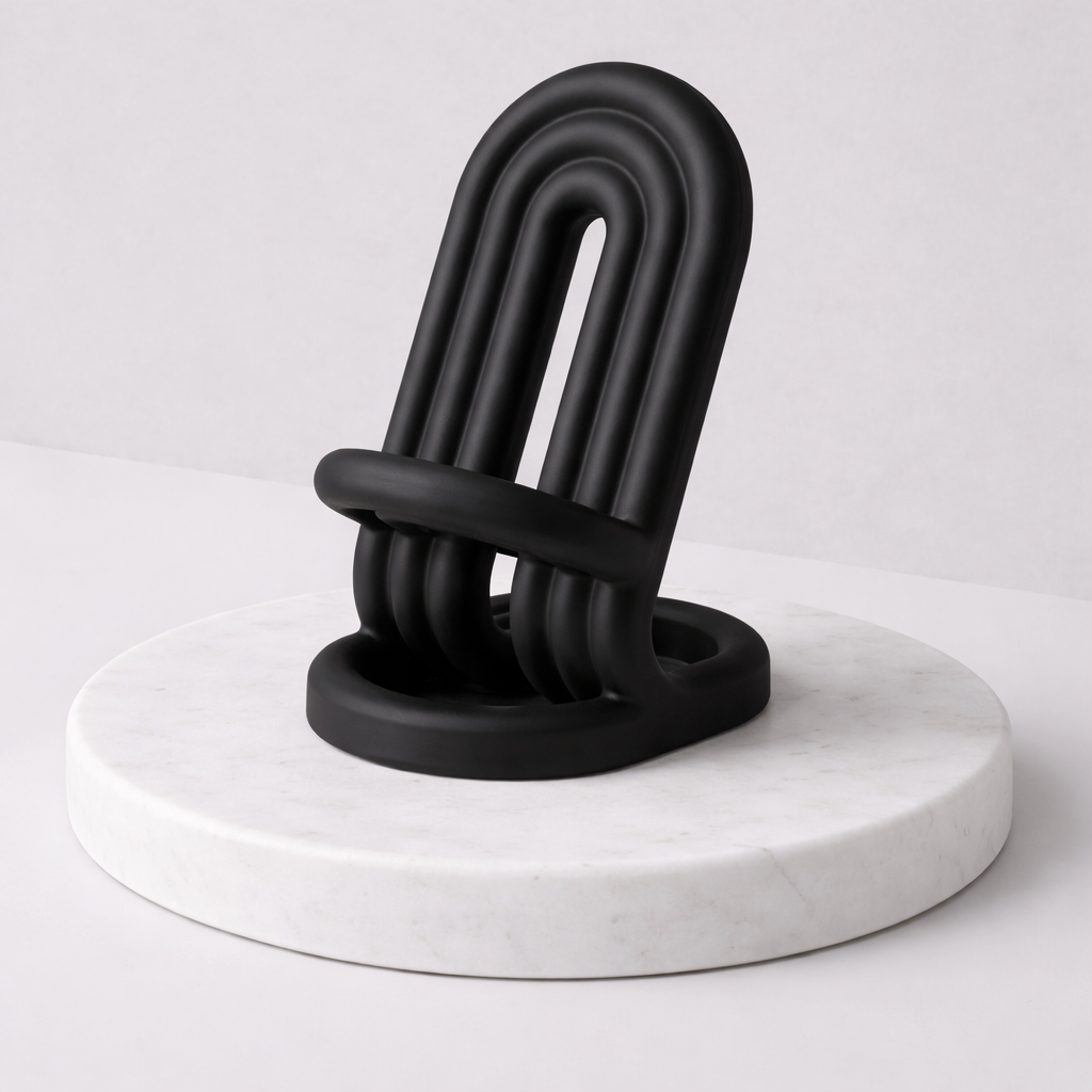 Black abstract sculpture on a white marble base