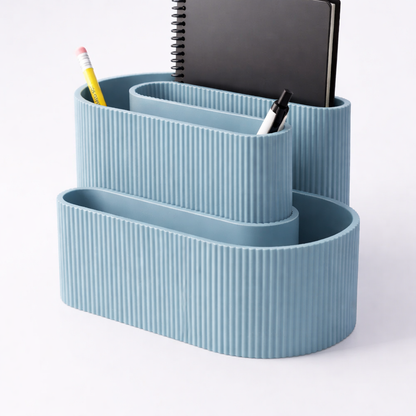Blue ribbed desk organizer with stationery items on a white background