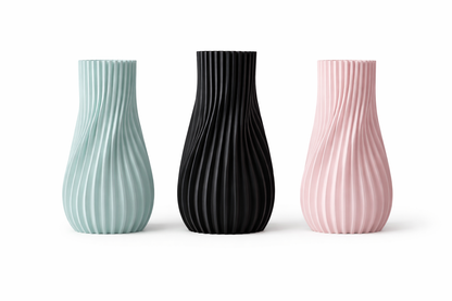 Three textured vases in green, black, and pink on a white background