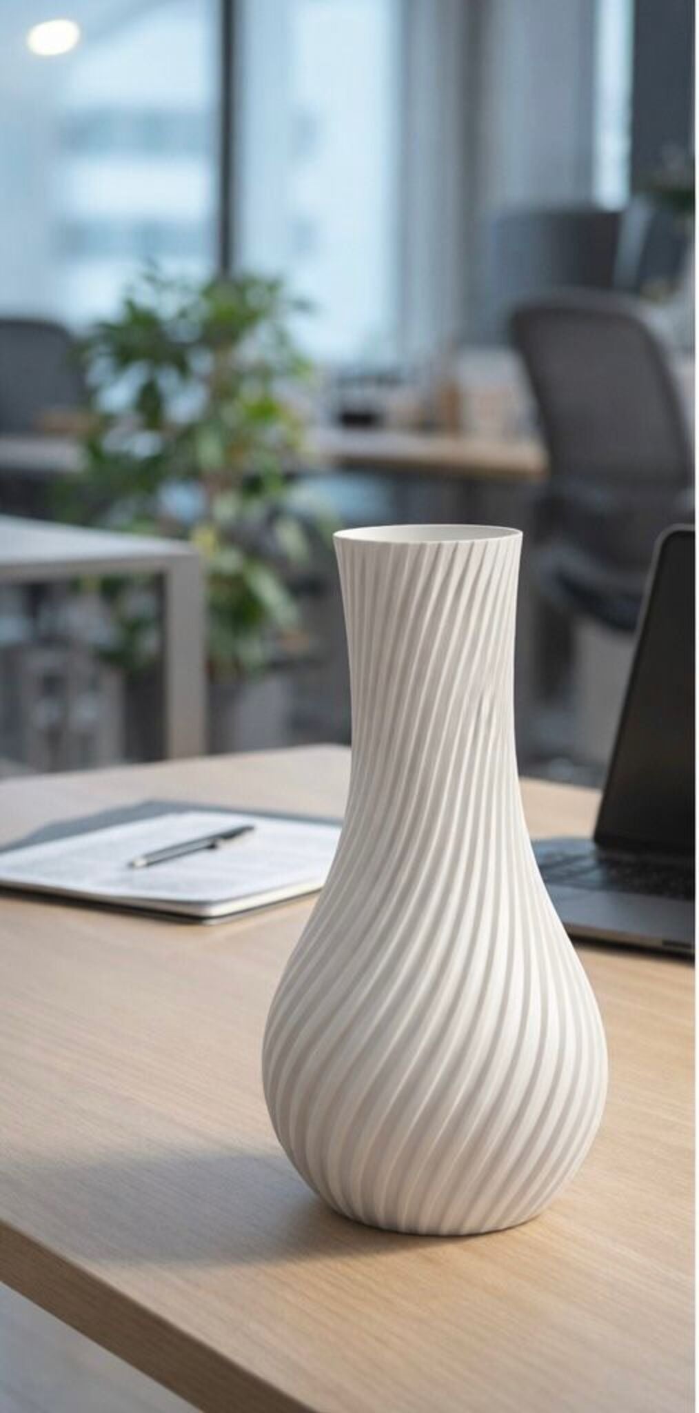 White textured vase on a wooden surface with a blurred office background