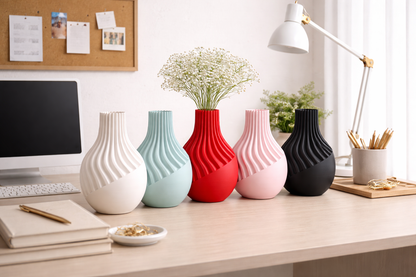 Colorful vases on a desk with a computer and office supplies in the background