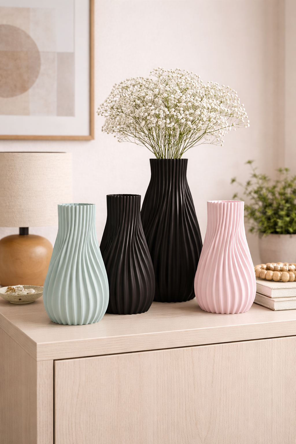 Four vases of different colors and designs on a wooden surface with a neutral background.